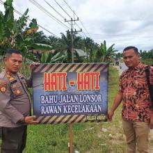 Kapolsek Kabun Pasang Spanduk Himbauan Jalan Rusak Di Rohul